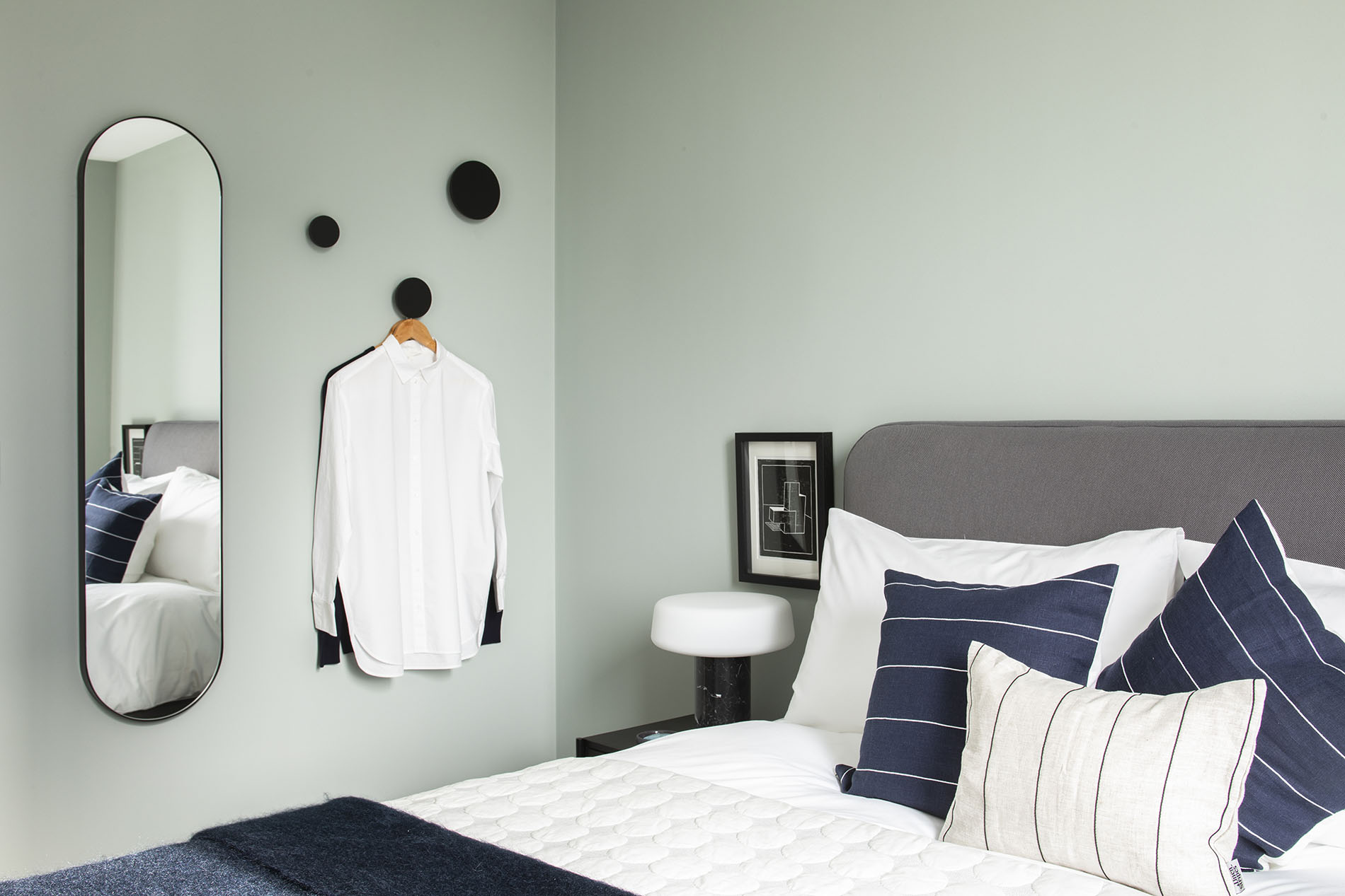 Bedroom with mirror and hanging clothes Bedroom with mirror and hanging clothes