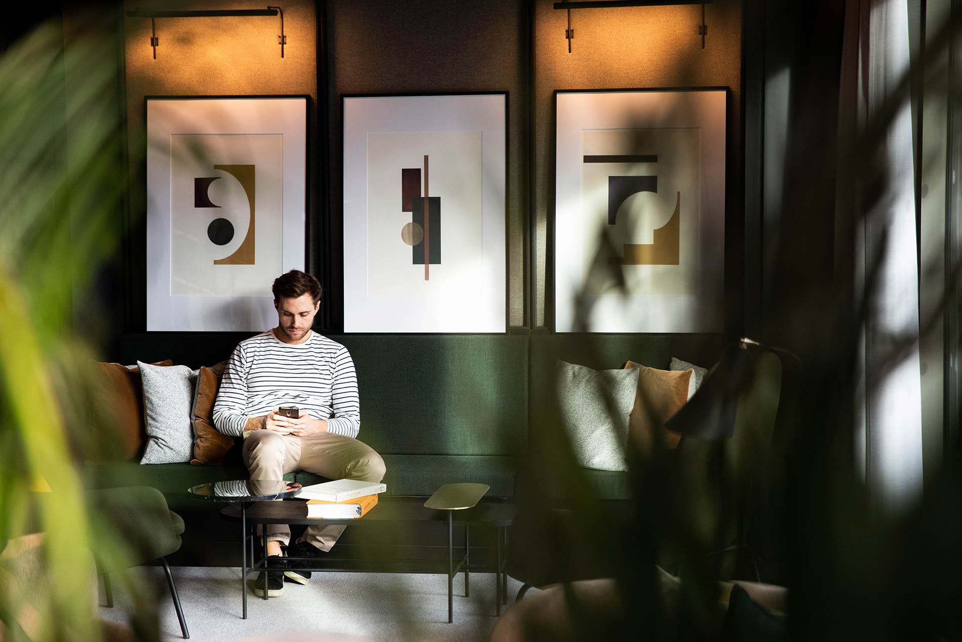 Man sitting on green sofa with phone Man sitting on green sofa with phone