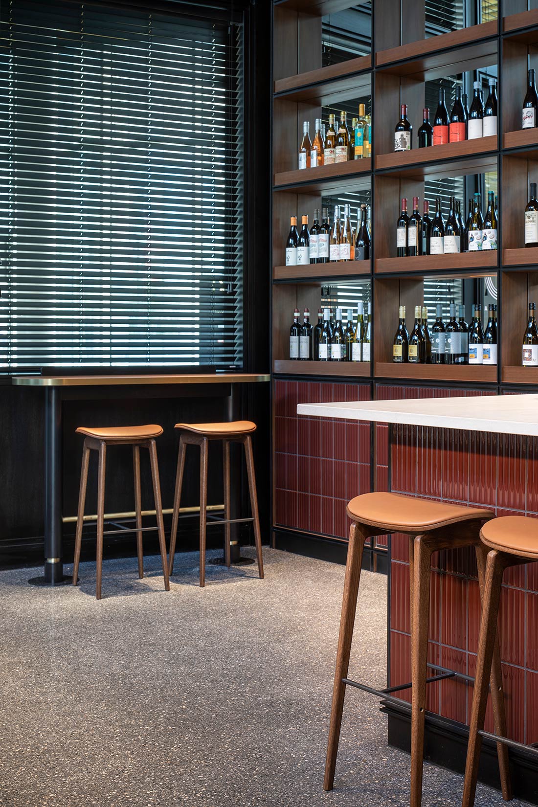 Bar area with stools and wine bottles
